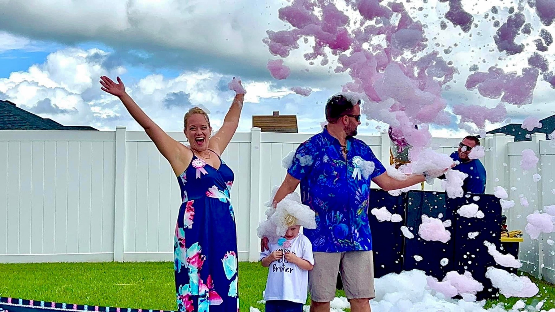 Family celebrating gender reveal with pink foam